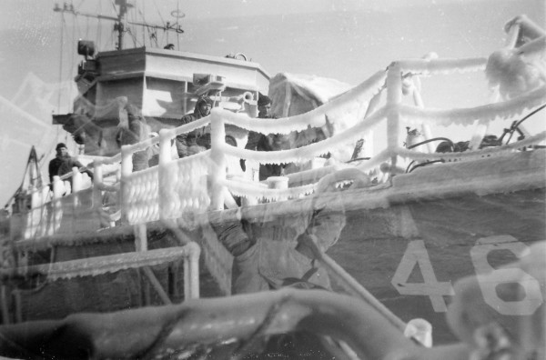 YMS-468 and crew; Left to right: Harold C Foster Jr., SoM3c (deckhand) of Birmingham, AL and Ambruzzi (Gunner's Mate, GM); ice accumulation while sweeping approaches to Chesapeake Bay, MD; Winter 1944